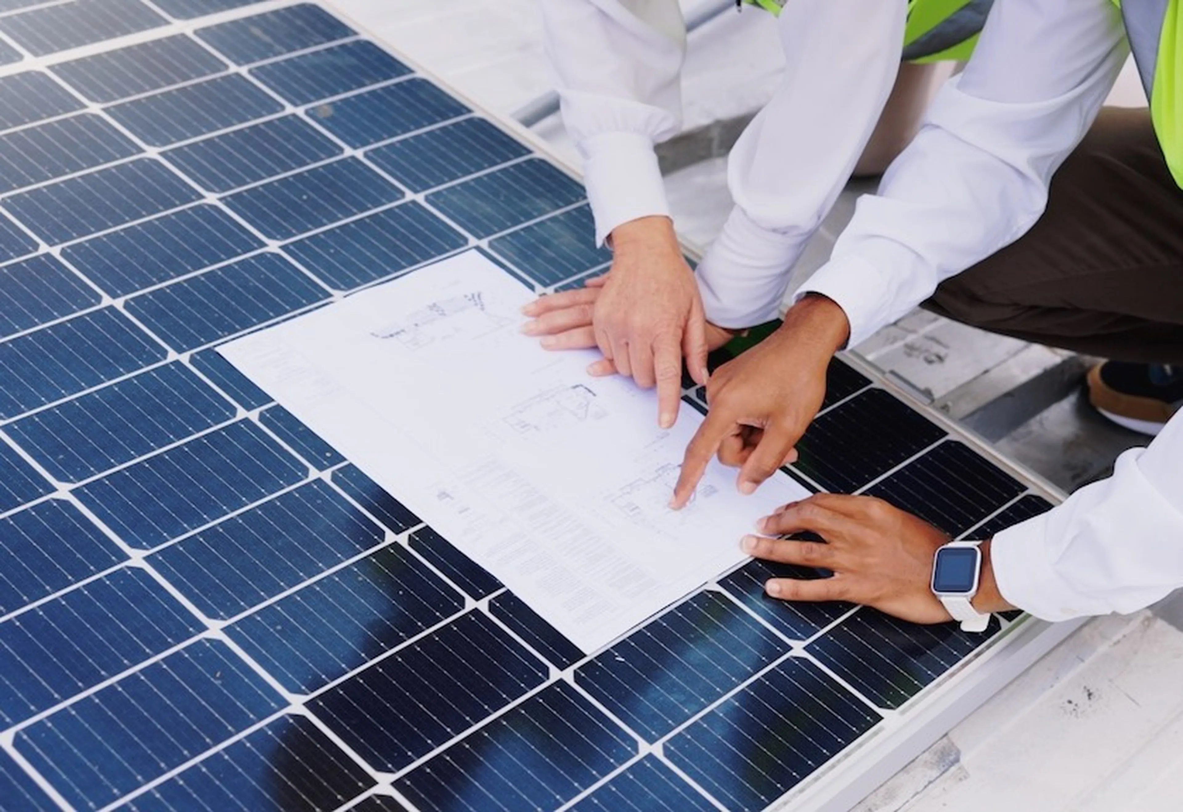 Zwei Personen schauen sich einen Plan einer Erneuerbaren-Energie-Anlage an.