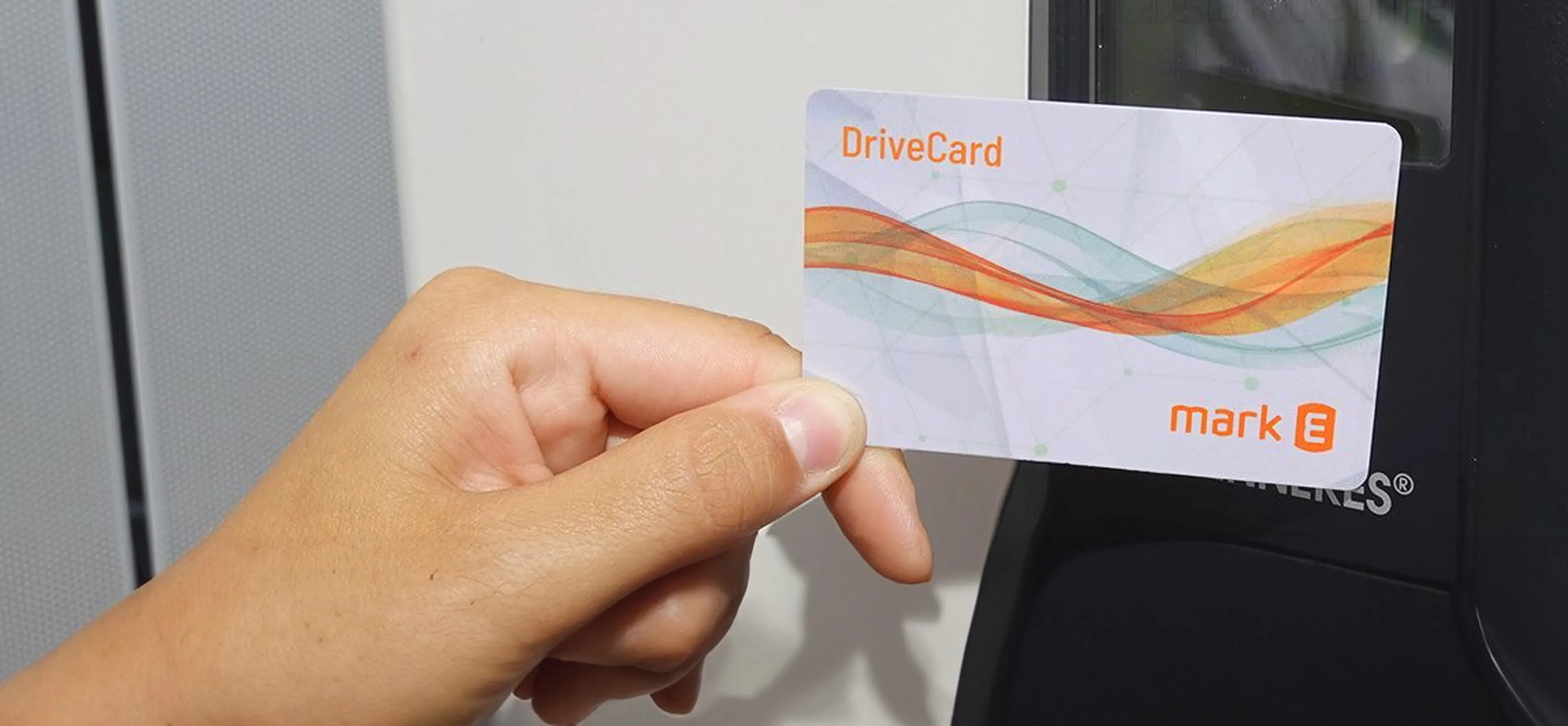 Die Mark-E Drivecard wird vor ein Ladegerät gehalten.