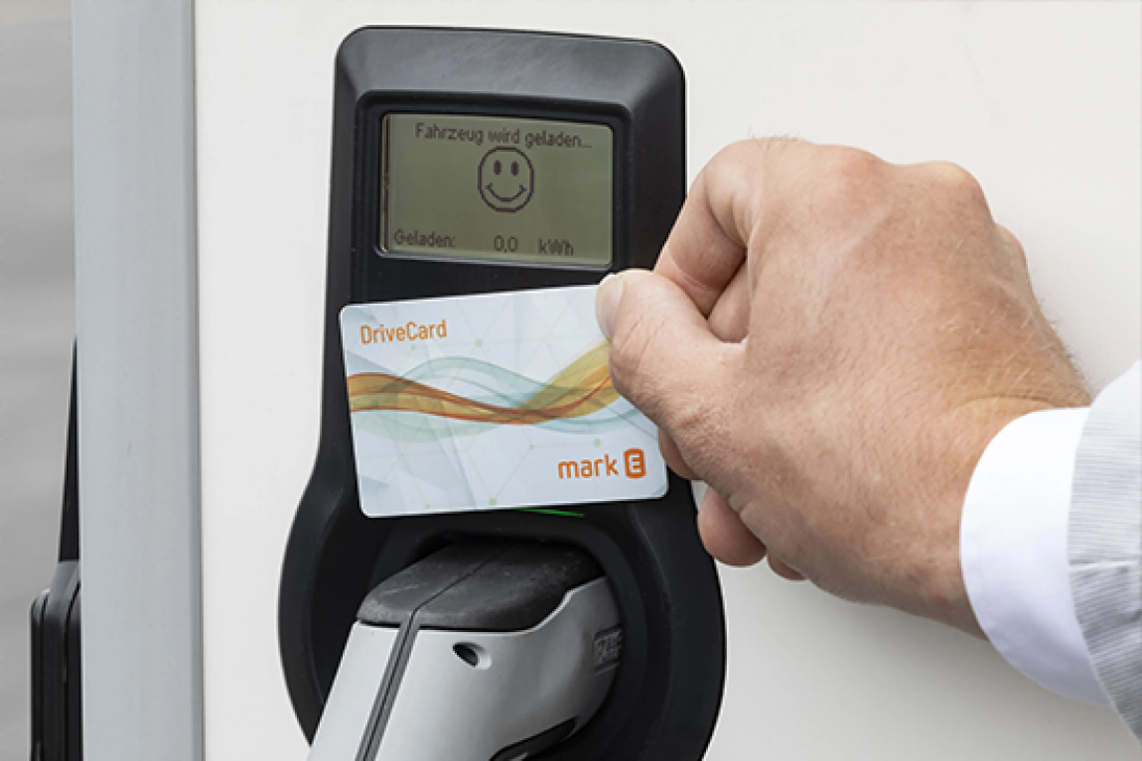Hand hält eine Mark-E DriveCard an eine Ladesäule – unkompliziertes Laden mit Mark-E Strom