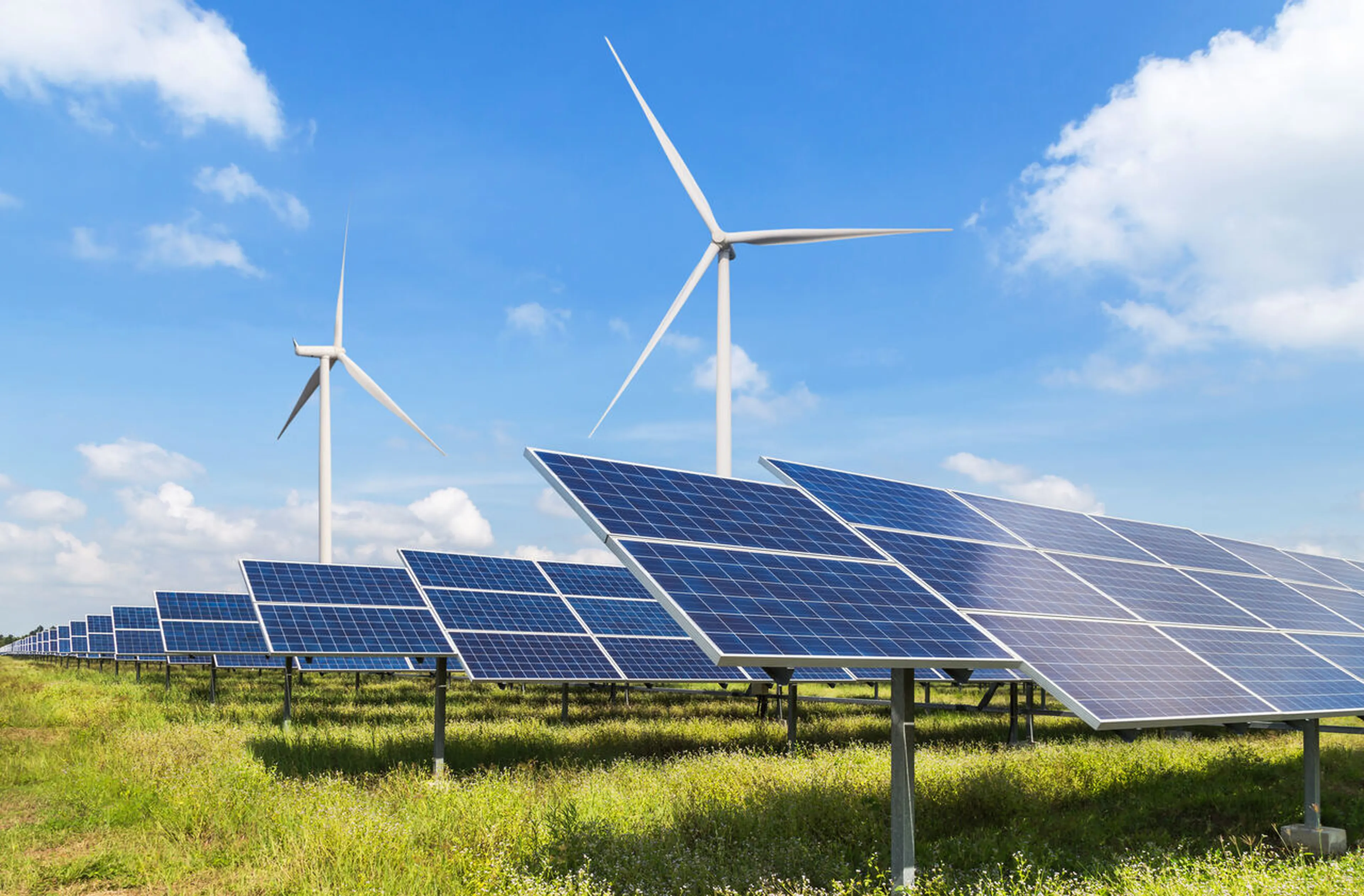 Photovoltaik-Park mit zwei Windkraftwerken im Hintergrund