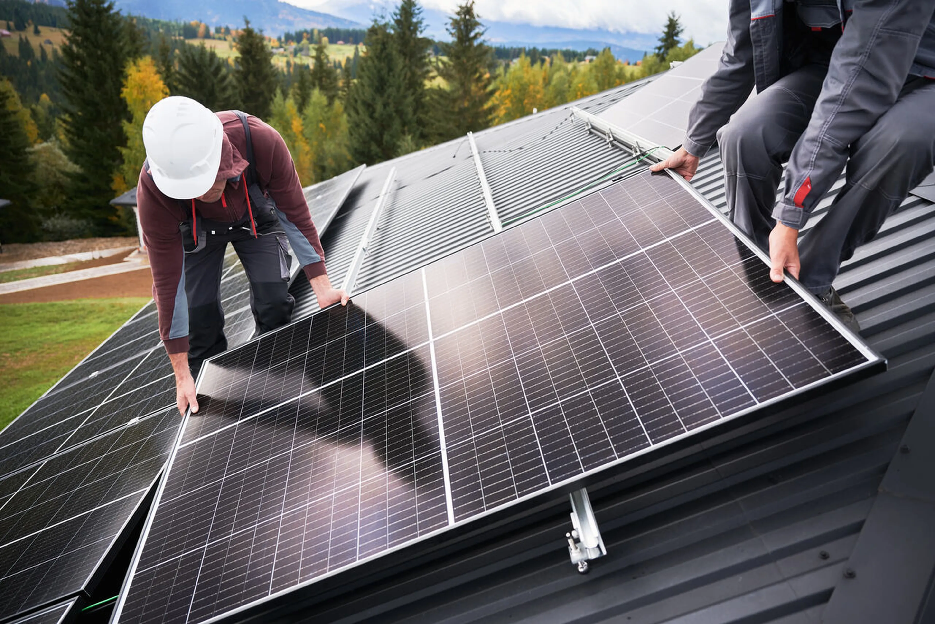 Techniker installieren ein PV-Paneel auf einem Dach