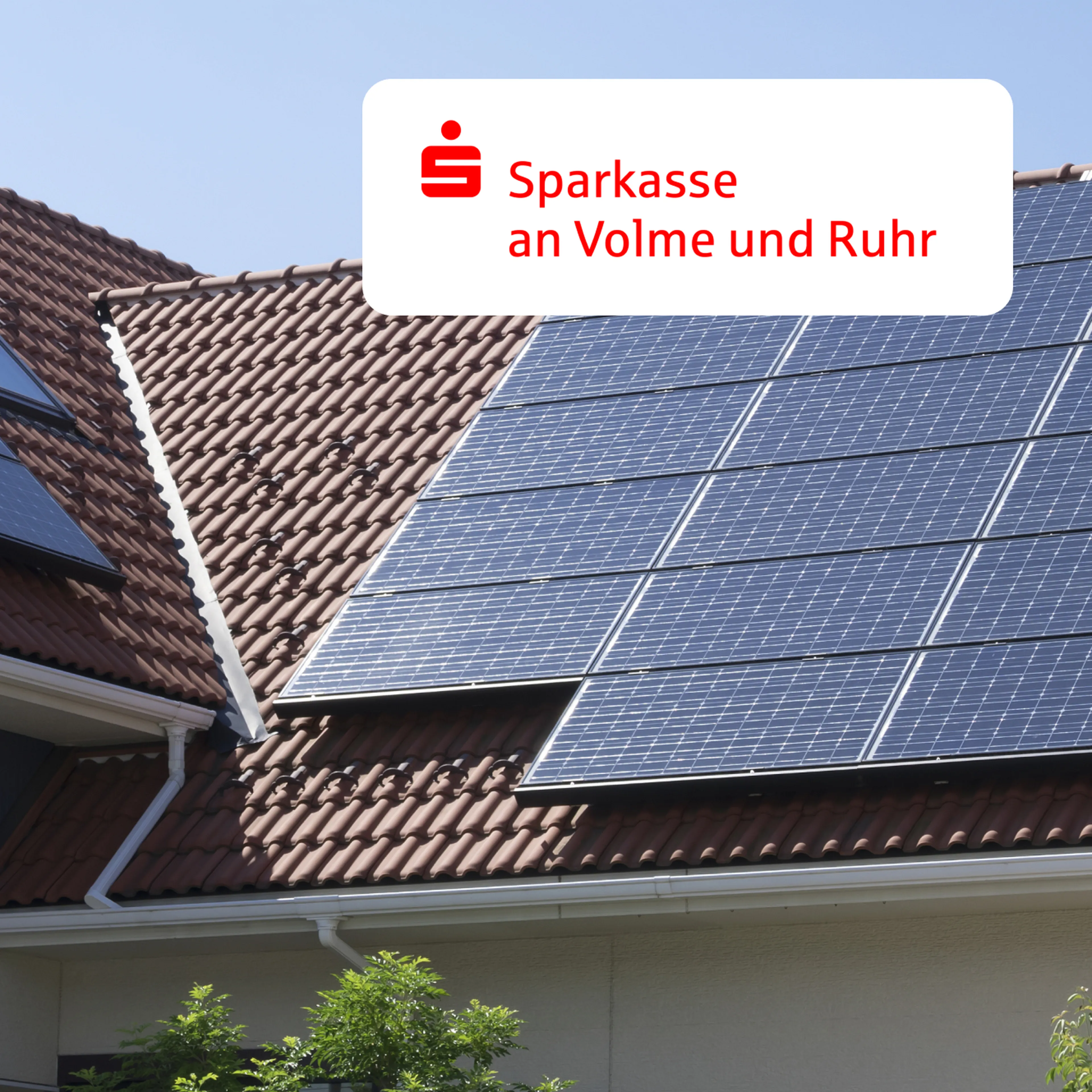 Sonnenkollektoren auf einem roten Ziegeldach mit einem Logo der Sparkasse an Volme und Ruhr in der Ecke.