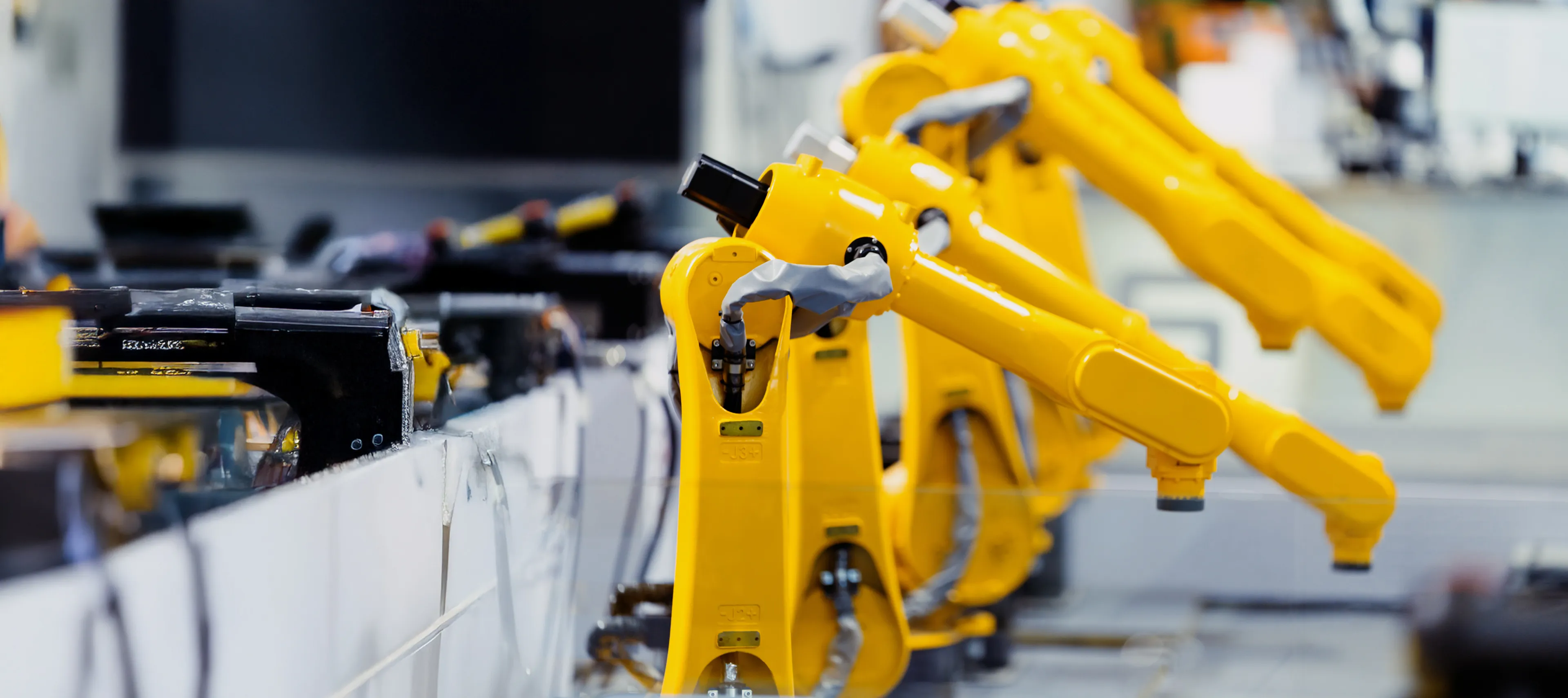 Gelbe Roboterarme in einer automatisierten Produktionslinie