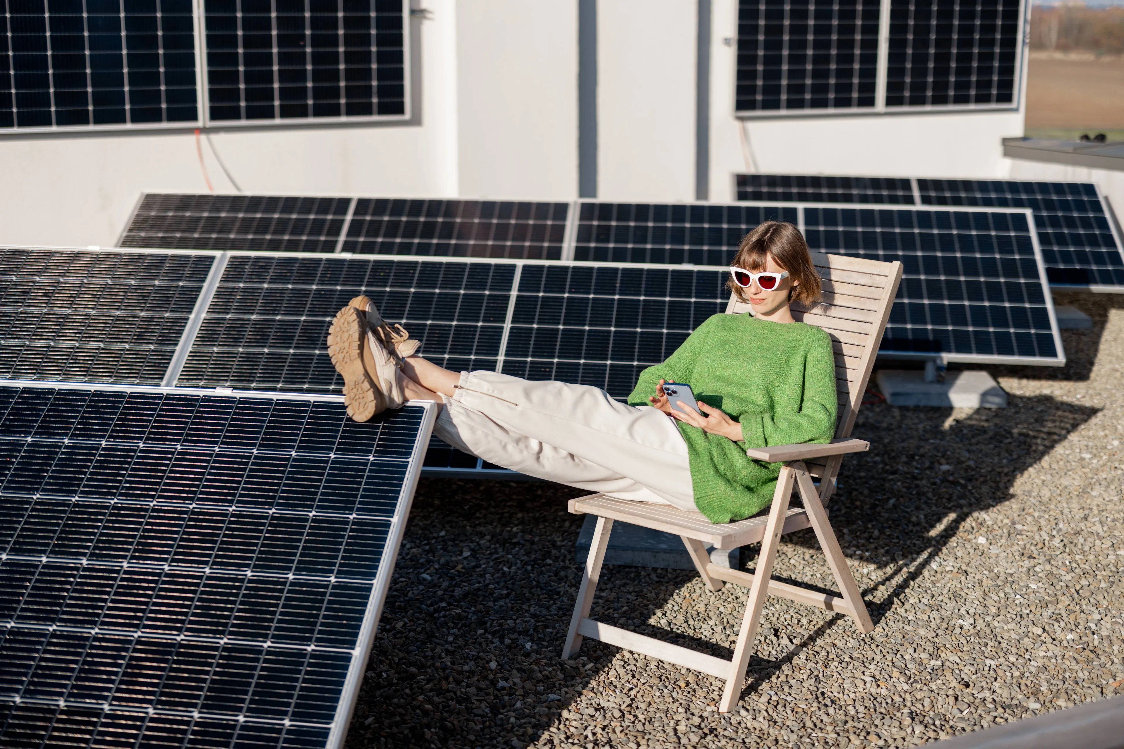 Frau entspannt auf einem Liegestuhl zwischen Solarpanels – nachhaltiger Strom für Mieter mit Mark-E.