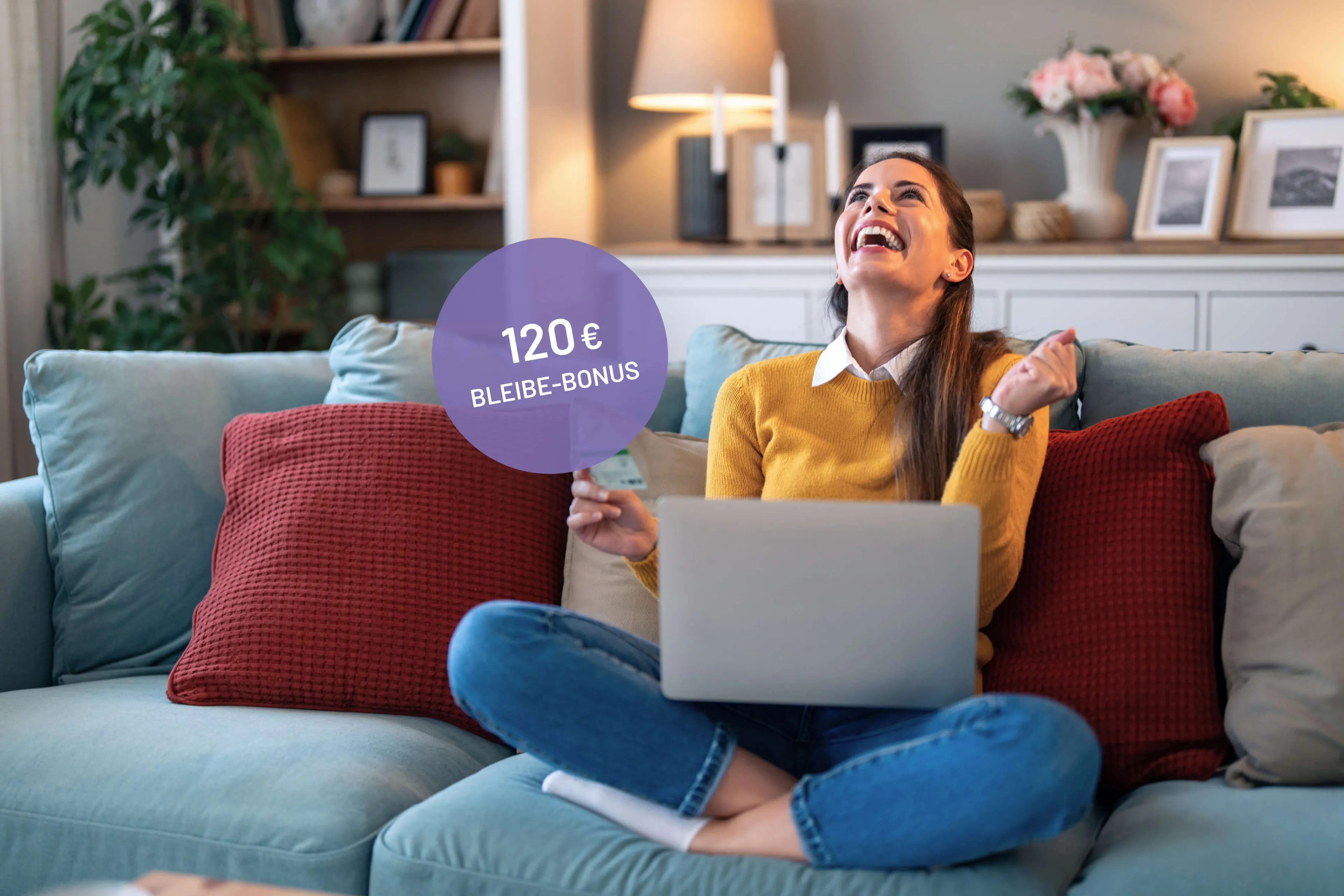 Frau auf Couch mit Laptop freut sich