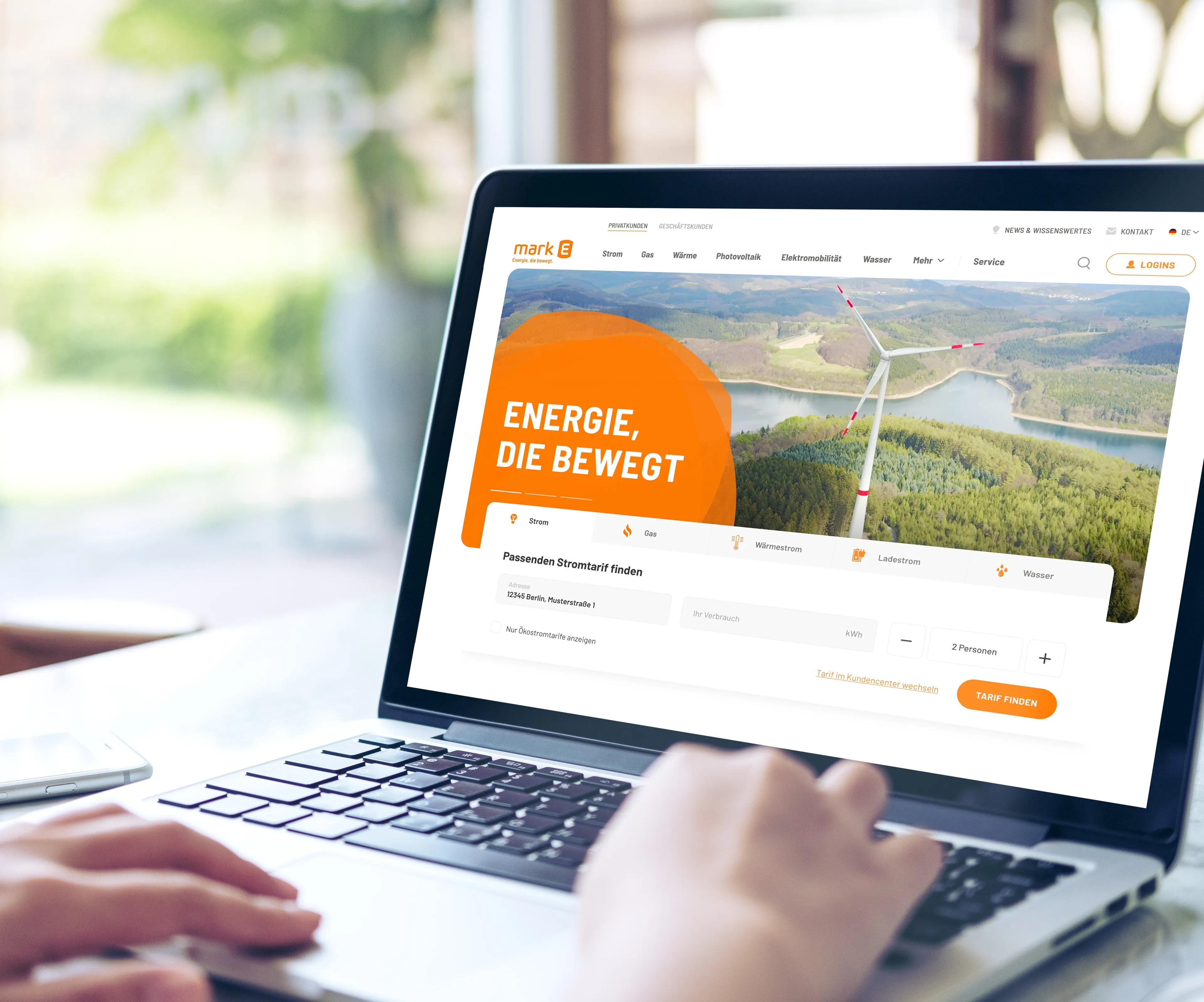 Person sitzt an einem Laptop. Es sind nur die Hände zu sehen und auf dem Bildschirm ist die Mark-E Startseite geöffnet.