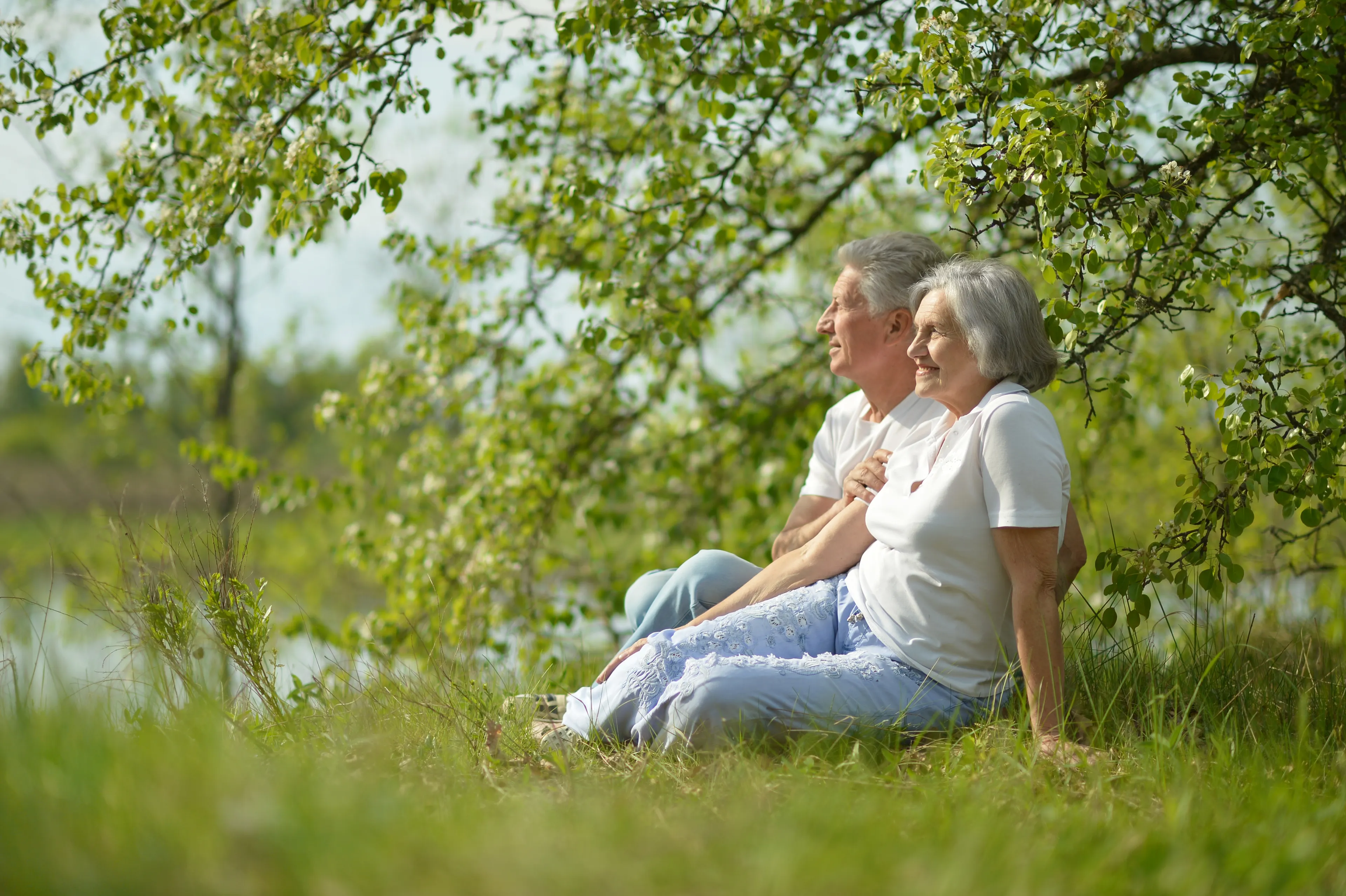 Älteres Paar sitzt entspannt im Grünen – klimafreundlich heizen mit Klima Fair Gas von Mark-E.