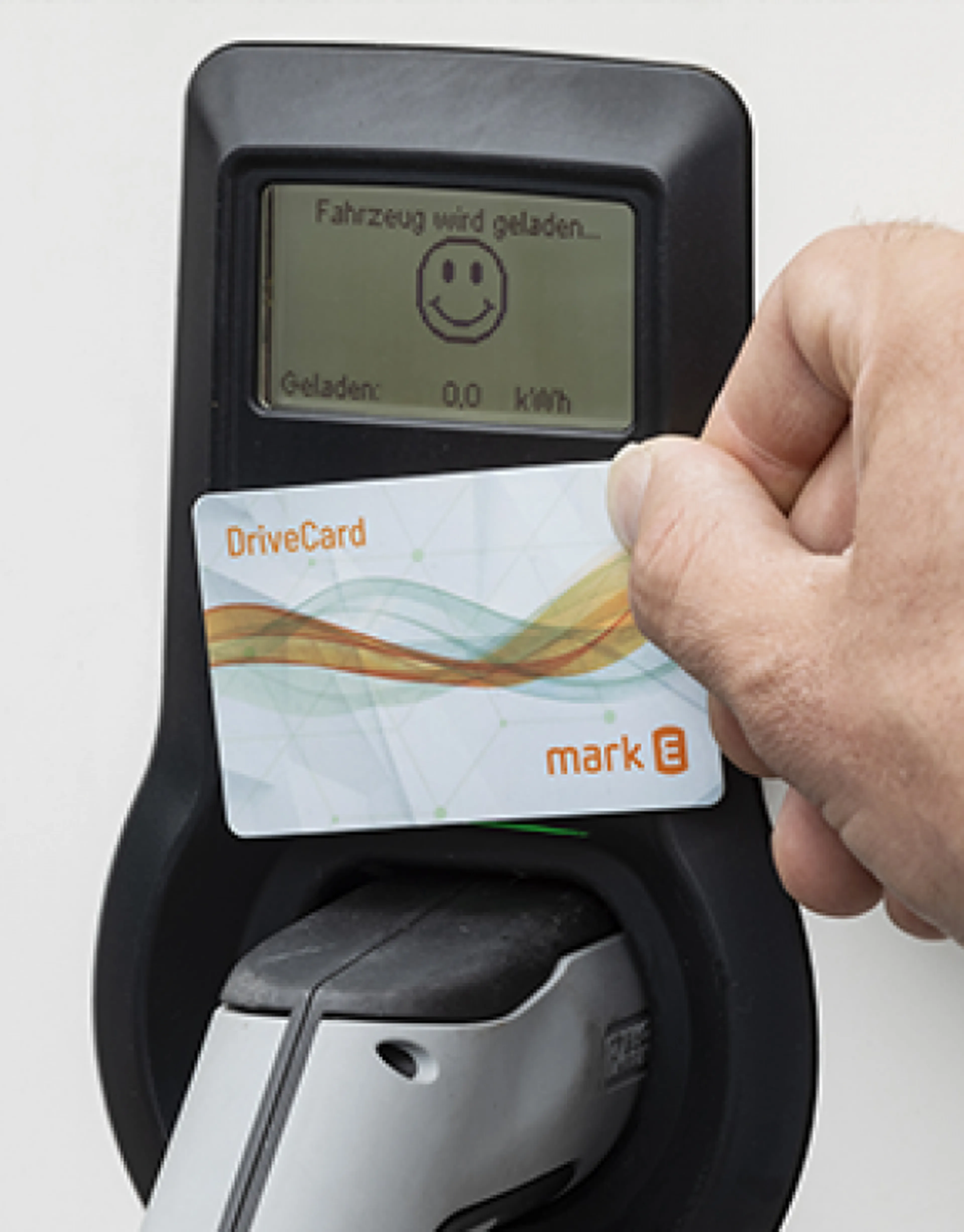 Hand hält eine Mark-E DriveCard an eine Ladesäule – unkompliziertes Laden mit Mark-E Strom