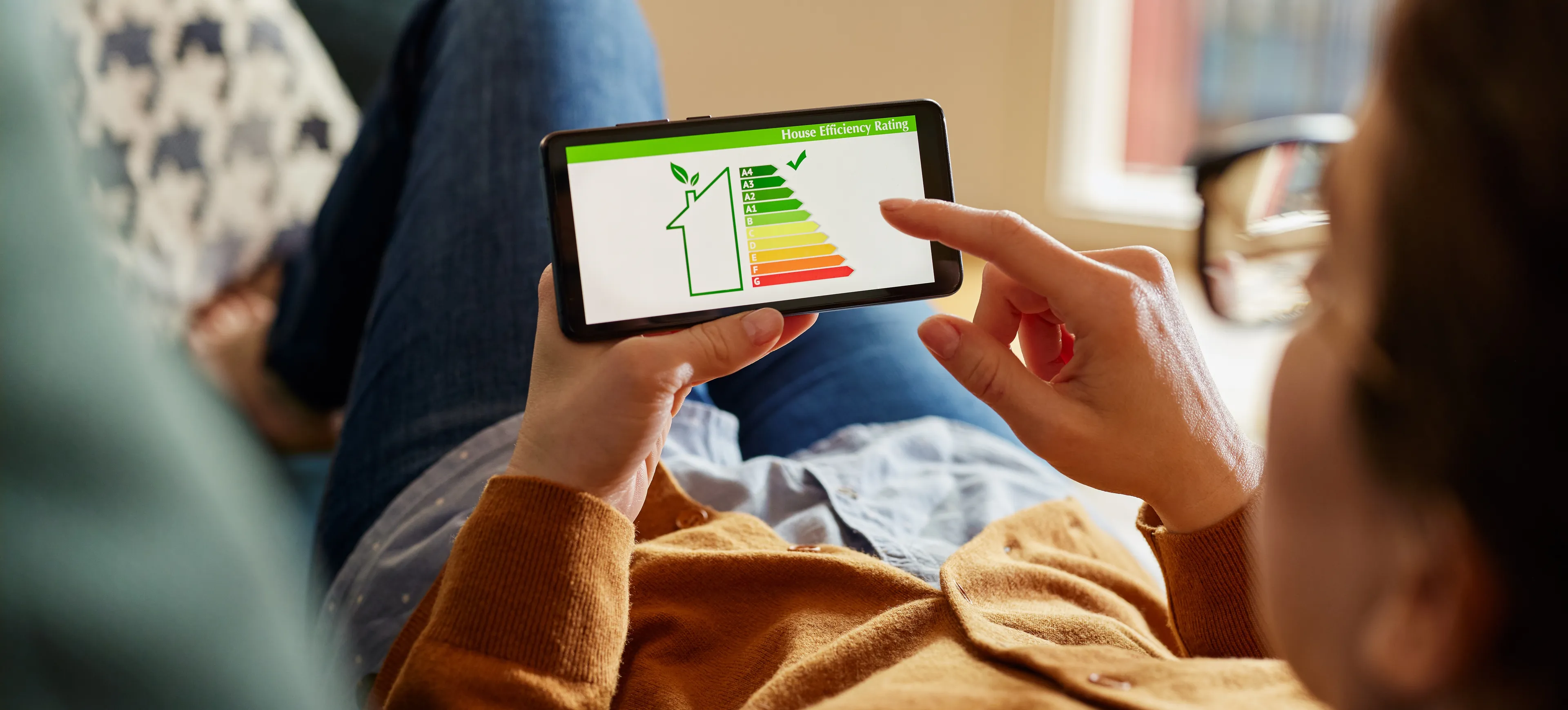 Mann schaut sich auf einem Handy die Energieeffizienzklassen an.