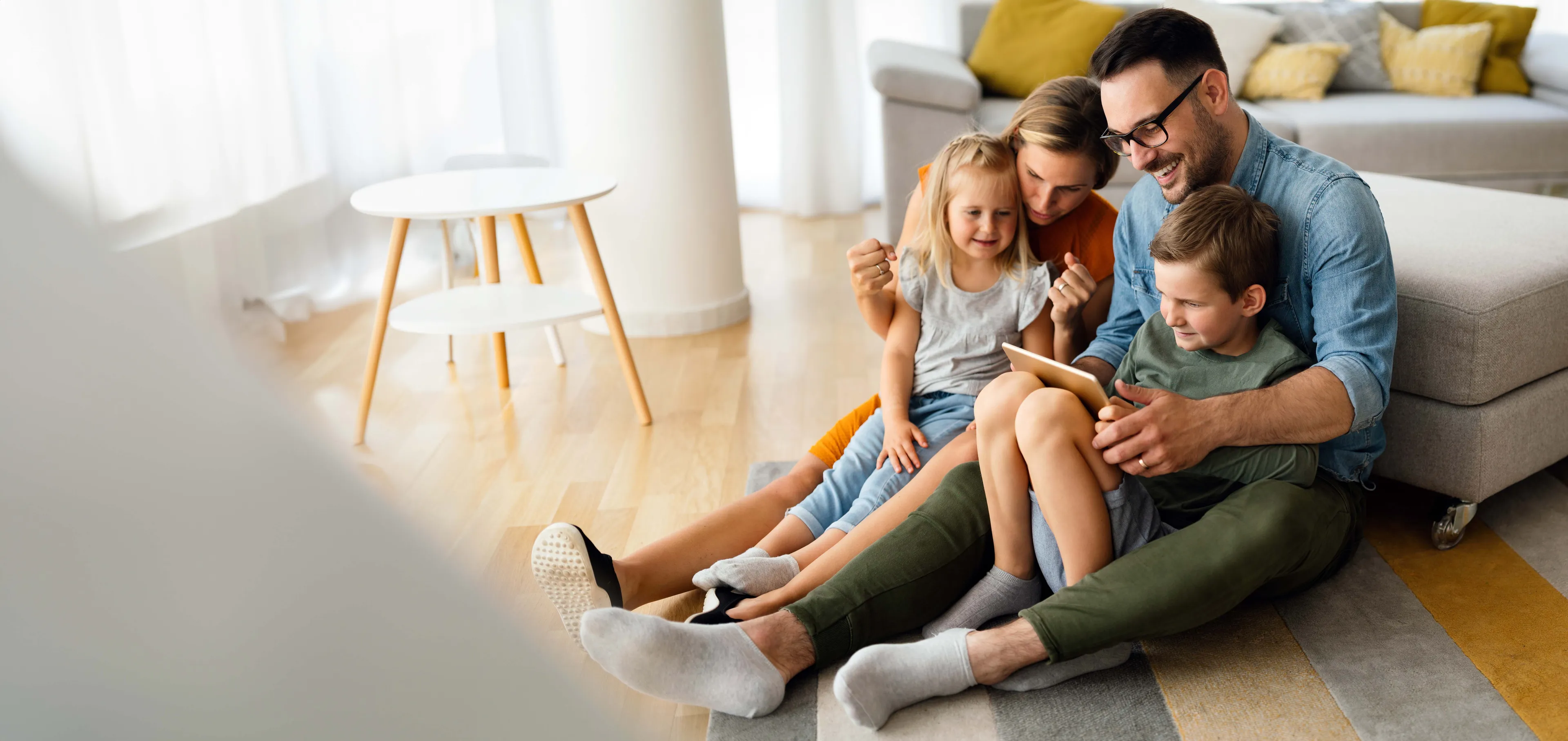 Familie im Wohnzimmer nutzt Tablet